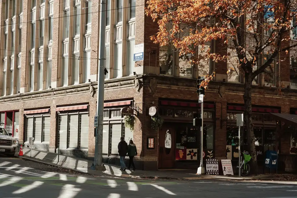 A Seattle street corner with brick buildings and autumn trees