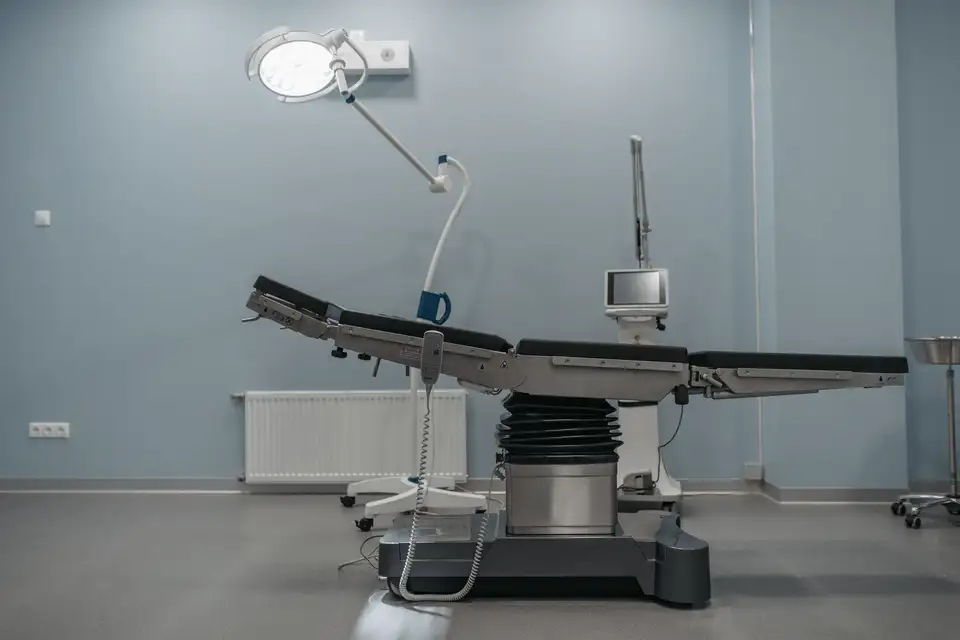 An empty operating room with a surgical table and overhead lights